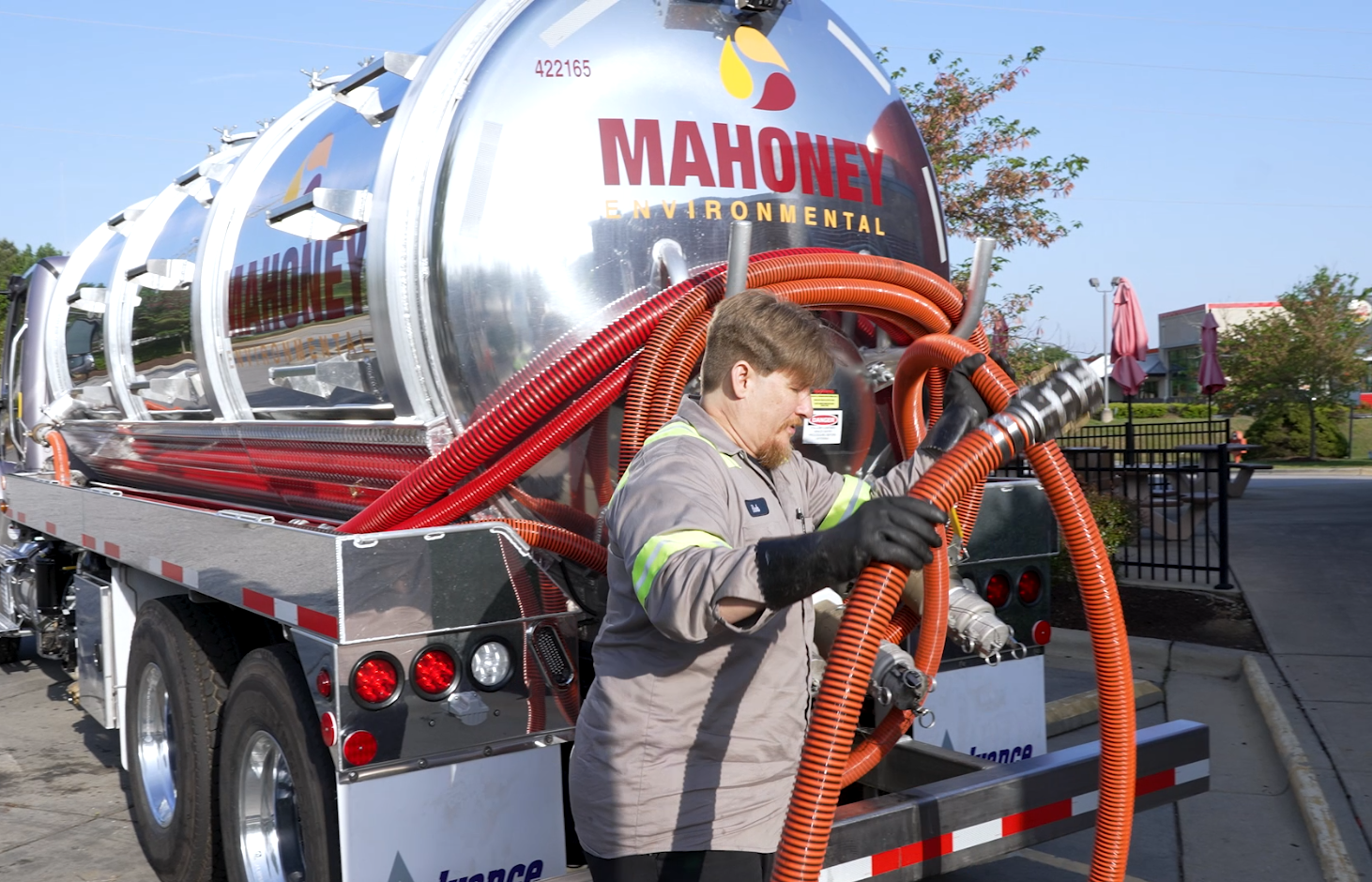 Mahoney Environmental driver unraveling pump hose on truck