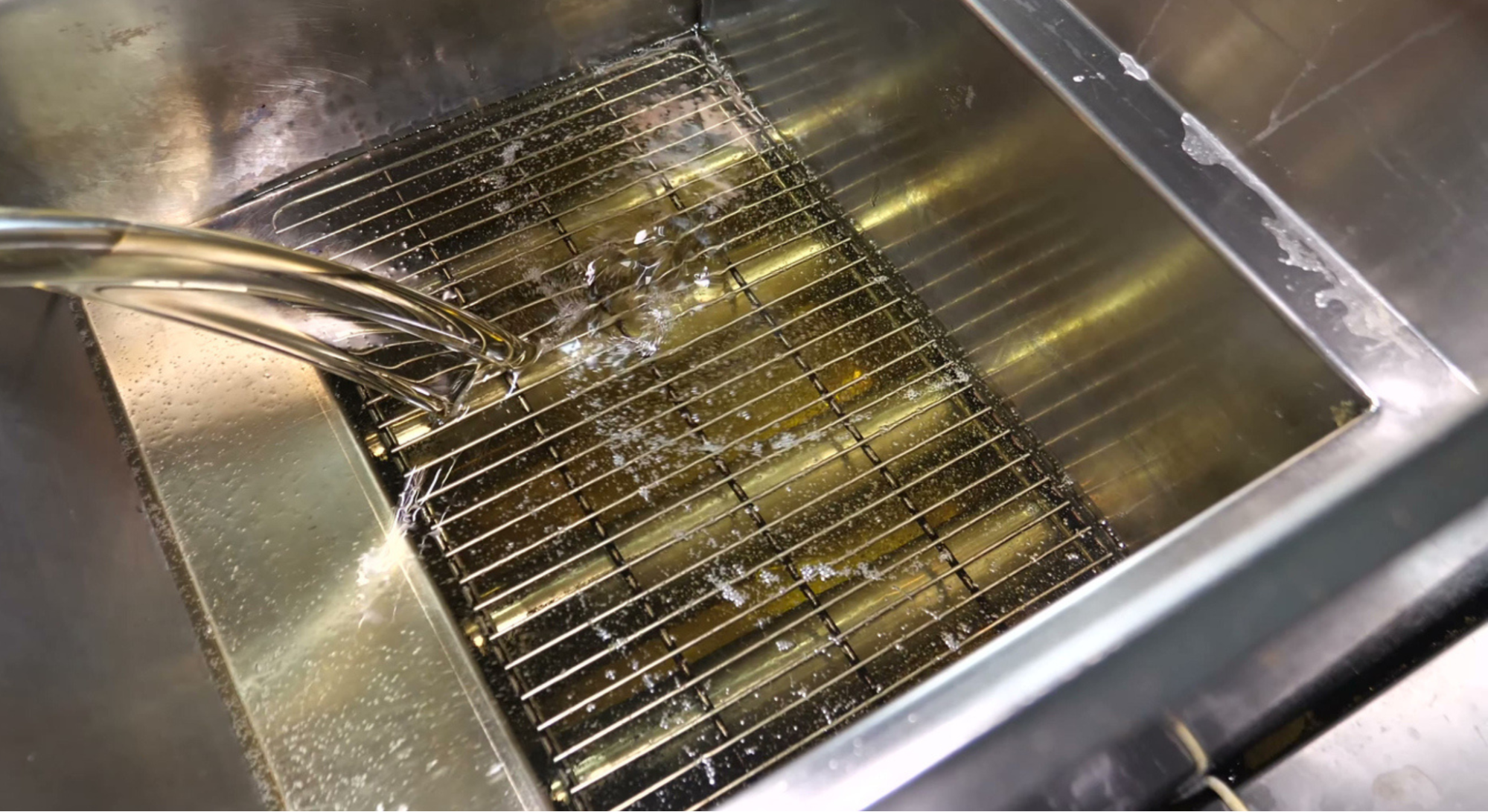 stock image of adding oil into a fryer