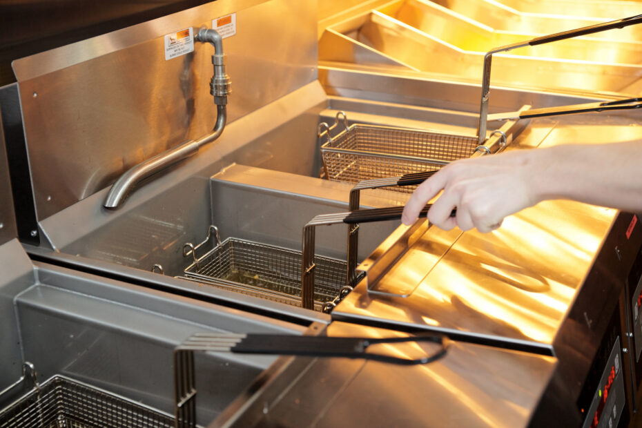 Deep fryer with boiling oil on restaurant kitchen